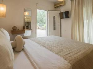 a large white bed in a room with a window at Julys House in Parga
