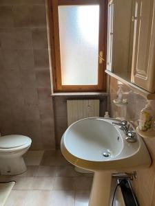 a bathroom with a white sink and a toilet at Appartamento immerso nel verde in Campo di Giove +70 photos