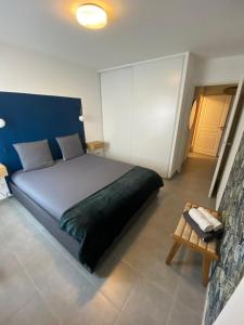 a bedroom with a large bed with a blue headboard at Élégant T3 au Panier Vieux Port avec Terrasse Privée et Parking in Marseille