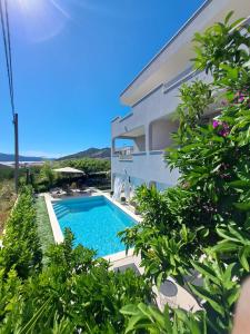 a swimming pool in front of a building at Paulina Harmony Rooms in Seget Vranjica