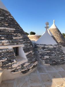 une image d'un bâtiment en pierre avec un toit dans l'établissement I PapaTrulli MiniResort, à Martina Franca