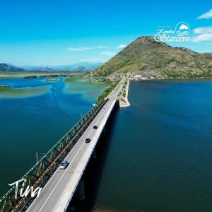 a bridge over a body of water with cars on it at Apartmani Konoba Starčevo in Virpazar