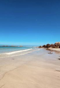 a sandy beach with rocks in the ocean at Ty Koant in Cléder