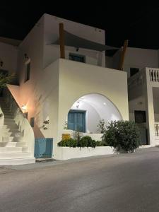 a white house with a round window and stairs at Atlantida Spacious Flat in Fira