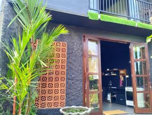 a facade of a house with a door and some plants at KUBU BLACK HOUSE in Jembrana