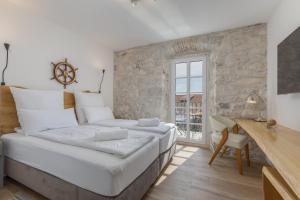 a large bed in a room with a stone wall at NEW - Casa Columba - 4 Star Design Boutique Hotel with Outdoor Pool & Private Garden in Makarska +37 photos