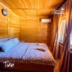 a bedroom with a bed in a wooden cabin at Apartmani Konoba Starčevo in Virpazar
