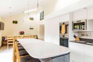 a kitchen and dining room with a white table at Thornyfield Barn in Winster