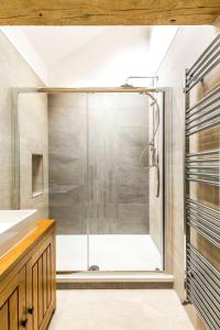 a shower with a glass door in a bathroom at Thornyfield Barn in Winster