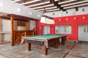 einen Billardtisch in einem Zimmer mit roter Wand in der Unterkunft Casa de vacaciones con piscina y espacio recreativo in Santiago del Estero