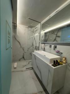 a white bathroom with a sink and a mirror at Mare Suites 4 in Chania +31 photos