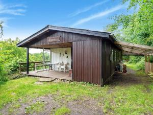 a shed with a table and chairs on a deck at 6 person holiday home in Spøttrup-By Traum in Lihme