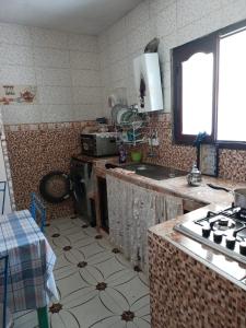 een keuken met een spoelbak en een fornuis bij Casa Youssef 1 in Asilah