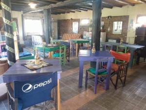 un ristorante con tavoli e sedie in una stanza di La Comarca Hostel de Montaña a Potrerillos