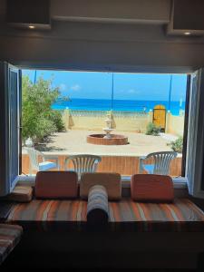 un sofá en una sala de estar con una gran ventana en مطروح شاطيء الأبيض عالبحر مباشر, en Marsa Matruh