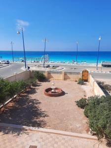 un parque con una fuente frente a la playa en مطروح شاطيء الأبيض عالبحر مباشر, en Marsa Matruh