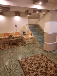 Habitación con escalera, sofá y alfombra. en مطروح شاطيء الأبيض عالبحر مباشر, en Marsa Matruh