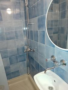 a blue tiled bathroom with a sink and a mirror at Double Room Sucuraj 6734b in Sućuraj