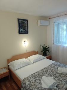 sypialnia z dużym białym łóżkiem i oknem w obiekcie Rooms by the sea Sucuraj, Hvar - 6734 w mieście Sućuraj