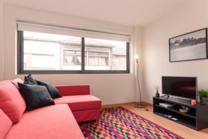 sala de estar con sofá rojo y TV en Picaria Apartment, en Oporto