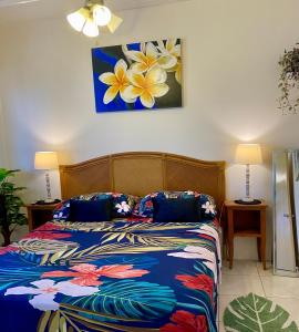a bedroom with a bed and a painting on the wall at Heiata Lodge Papeete in Papeete