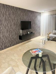 un salon avec une table et une télévision dans l'établissement Magic Living LUXURY 27 Neuf avec Smart TV, à Casablanca