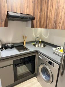 une cuisine avec une machine à laver et un évier dans l'établissement Magic Living LUXURY 27 Neuf avec Smart TV, à Casablanca 17 autres photos