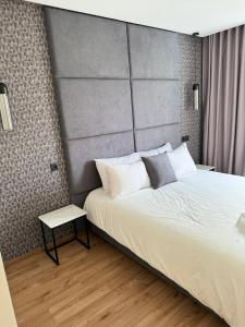 une chambre avec un grand lit avec une grande tête de lit dans l'établissement Magic Living LUXURY 27 Neuf avec Smart TV, à Casablanca