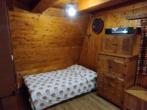 a bedroom with a bed in a wooden room at Lovely wooden cabin in Log pod Mangartom