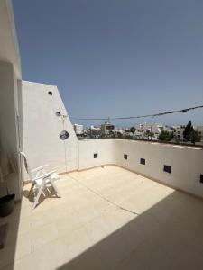 a white chair sitting on top of a balcony at Apartment Monastir Centre in Monastir