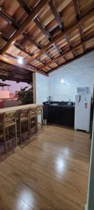 a room with a table and chairs and a refrigerator at Chalé Campo Florido in São Roque de Minas