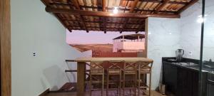 a kitchen with a table in a room with a view at Chalé Campo Florido in São Roque de Minas