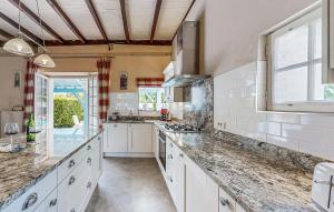 a large kitchen with white cabinets and a window at 4 Bedroom Stunning Home In Escos in Escos