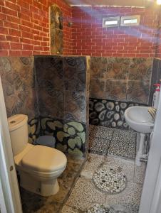 a bathroom with a toilet and a sink at Linkgreen Homestay Lombok in Tetebatu