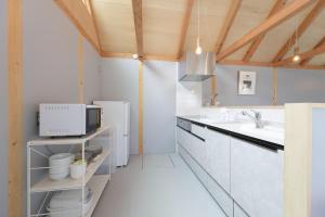 a kitchen with white counters and a sink at Soleil MIURA in Miura
