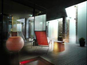 a living room with a red chair and a table at Hotel Traube am See in Friedrichshafen +79 photos
