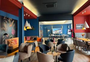 a restaurant with blue walls and chairs and tables at Hôtel Villa Des 2 Caps in Wimereux