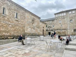 a group of people sitting at tables in front of a building at The Cliffs - Casa Catuxa in Viveiro