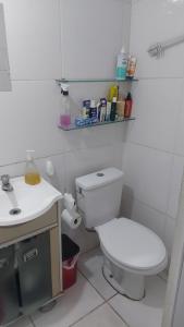 een badkamer met een wit toilet en een wastafel bij Kitinete final de rua centro in Itajaí