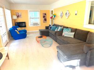 a living room with a brown couch and blue chairs at Casa San Diego - Spacious Getaway with Backyard, Firepit, Kid Zone in San Diego