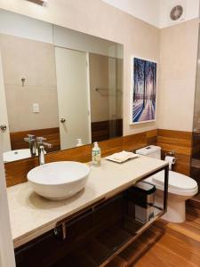 un bagno con lavandino, WC e specchio di MONTERRICO POLO APARTS #17 - Dpto de estreno con Balcón Frente Embajada USA a Lima