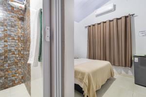 a bedroom with a bed and a brick wall at Pousada Por do Sol in Pirenópolis +17 photos