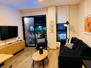 un soggiorno con divano nero e TV a schermo piatto di MONTERRICO POLO APARTS #17 - Dpto de estreno con Balcón Frente Embajada USA a Lima