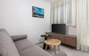 a living room with a couch and a flat screen tv at Gorgeous Apartment In Omisalj in Omišalj