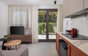 a kitchen and living room with a tv and a table at Gorgeous Apartment In Omisalj in Omišalj