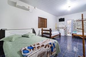 a bedroom with a bed with a green comforter at Pousada Por do Sol in Pirenópolis
