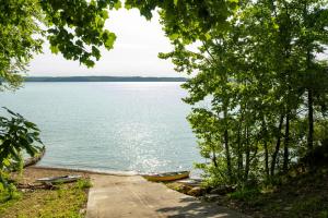 a path next to a lake with boats on it at Fox Berry Hill - Lakefront with Dock, Launch & Hot Tub in Waverly