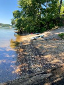 a boat laying on the shore of a body of water at Fox Berry Hill - Lakefront with Dock, Launch & Hot Tub in Waverly
