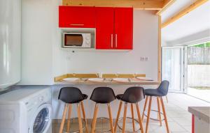 a kitchen with red cabinets and four bar stools at Gorgeous Home In Saint-Georges-De-Didon in Saint-Georges-de-Didonne