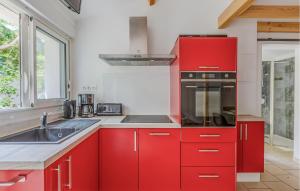a red kitchen with a sink and a stove at Gorgeous Home In Saint-Georges-De-Didon in Saint-Georges-de-Didonne